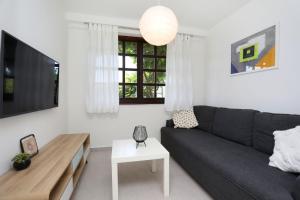 een woonkamer met een zwarte bank en een tafel bij Apartment Lina in Rabac