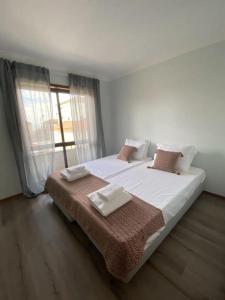 a bedroom with two beds and a large window at AMARÉ Guest House in Ovar