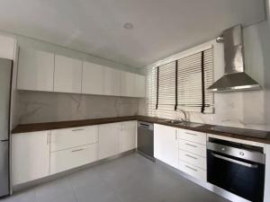 a kitchen with white cabinets and a stove top oven at AMARÉ Guest House in Ovar