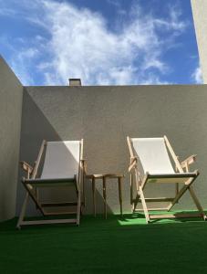 two chairs sitting next to each other next to a building at AMARÉ Guest House in Ovar +12 photos
