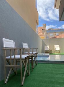 a patio with chairs and a table on a building at AMARÉ Guest House in Ovar