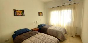 a bedroom with two beds and a window at Renda Iporava, Hermoso departamento en Salta in Salta