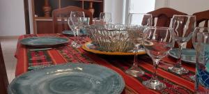 a table with wine glasses and a plate on it at Renda Iporava, Hermoso departamento en Salta in Salta