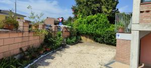 a backyard with a brick fence and plants at Silver Home in Bagnolo San Vito