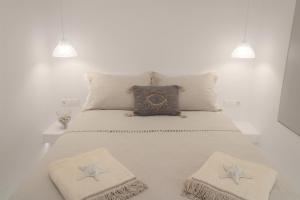 - un lit avec 2 oreillers et un réveil dans l'établissement Plaka Philoxenia Apartments, à Plaka Milou