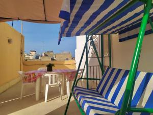 a balcony with a table and chairs and an umbrella at Casa Tavano in Avola