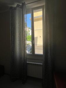 Zimmer mit einem Fenster mit Vorhängen und einem Heizkörper in der Unterkunft IL BARICENTRO in La Spezia