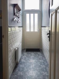 a bathroom with a door and a tile floor at De Malle Molen in Dinxperlo