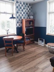 a dining room with a table and chairs and a tv at De Malle Molen in Dinxperlo