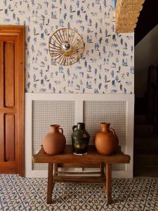 坎德萊達的住宿－Posada Albarea，一张桌子,两瓶花坐在墙上