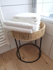 a basket shelf with towels on it in a bathroom at Boho Apartment Oldenburg in Oldenburg