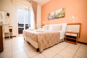 een slaapkamer met een groot bed met witte kussens bij Unique Hotel in Cesenatico