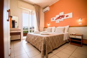 sypialnia z łóżkiem z pomarańczową ścianą w obiekcie Unique Hotel w Cesenatico