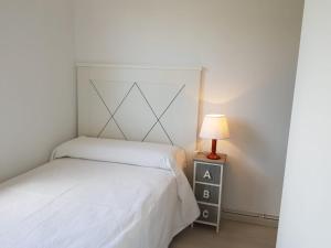 a bedroom with a bed and a lamp on a night stand at Chalet Major Beach Sanxenxo in Sanxenxo