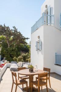 a wooden table and chairs on a patio at Matogianni Hotel in Mýkonos City
