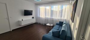 sala de estar con sofá azul y ventana en Belvedere Delux Apartment, en Deva