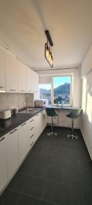 eine Küche mit weißen Schränken, einem Waschbecken und einem Fenster in der Unterkunft Belvedere Delux Apartment in Deva