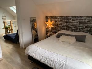 a bedroom with a brick wall and a bed at Le Cocon des Hortillonnages d'Amiens in Camon