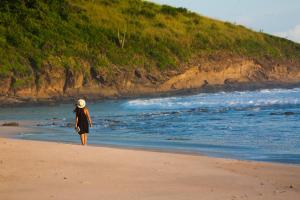波波尤的住宿－Hotel Punta Teonoste，站在海滩上看着大海的女人