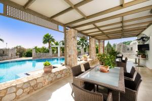 a patio with a table and chairs next to a swimming pool at Epavlis Akrotiri in Chania