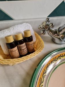 three bottles of essential oils in a basket next to a sink at Posada Albarea in Candeleda