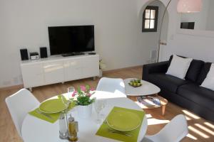 uma sala de estar com uma mesa branca e um sofá em Arles Hideaway - Le Duplex des Arènes em Arles