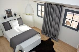 a bedroom with a bed and a window at Arles Hideaway - Le Duplex des Arènes in Arles