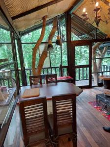 - une cuisine avec une table et des chaises dans une chambre dotée de fenêtres dans l'établissement The Tree House, à Hacienda Estela