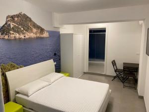 1 dormitorio con cama y vistas al océano en Torre del mare Rooms, en Bergeggi