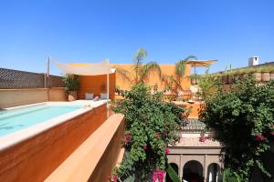 a house with a swimming pool and some flowers at Dar Akal in Marrakech