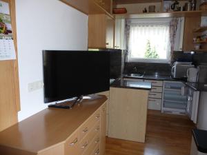 a kitchen with a flat screen tv on a counter at Ferienwohnung Eichenseher in Bodensdorf