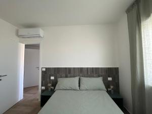 a bedroom with a large bed with a wooden headboard at Orti di Serapo -VERDE in Gaeta