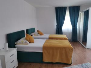 2 aparte bedden in een kamer met blauwe gordijnen bij Apartman Sali in Bihać