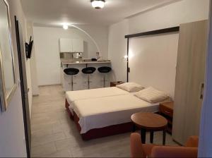 ein Schlafzimmer mit einem Bett und 2 Stühlen sowie eine Küche in der Unterkunft Guest House Blanka in Trogir