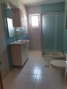 een badkamer met twee wastafels en een glazen douche bij Apartman Sali in Bihać