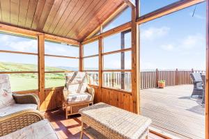 a screened in porch with chairs and a table at Pentref in Aberdyfi