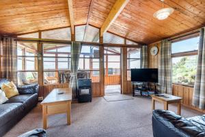 a living room with a couch and a tv at Pentref in Aberdyfi