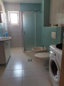een badkamer met een douche, een toilet en een wastafel bij Apartman Sali in Bihać +20 foto's
