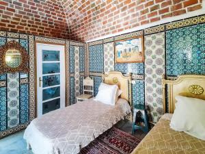 a bedroom with a bed and a brick wall at Hôtel Bou Fares in Sidi Bou Saïd