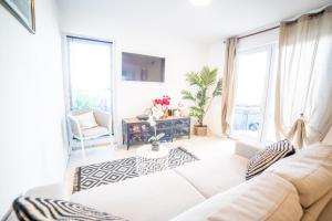 sala de estar con sofá blanco y ventanas en VILLA SUNNY BEACH CLIM ACCES PLAGE PARKING FAMILLE - TopProsConciergerie, en La Grande-Motte