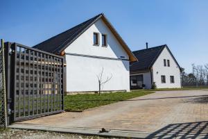 a white house with a fence in front of it at Apartmán Dvorce in Stráž nad Nežárkou