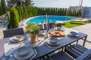 Villa Lumani ** Luxury residence near Split ** في Kučine: طاولة زرقاء عليها طعام بجوار حمام سباحة