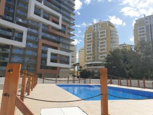 a swimming pool in front of some tall buildings at Elite Residense a 150 mts Praia da Rocha in Portimão