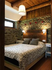 une chambre avec un lit et un mur en pierre dans l'établissement Arties Centro 2 habitaciones, exclusivo familias, à Arties