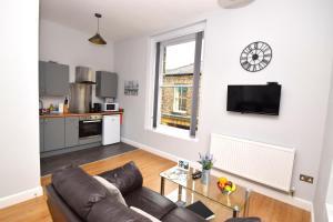 a living room with a leather couch and a table at Malton Central Apartments in Malton