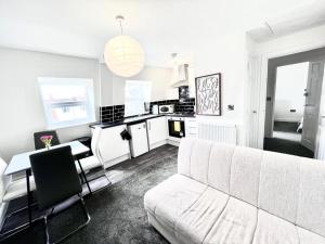 uma sala de estar com um sofá branco e uma cozinha em Weston Inn em Weston-super-Mare
