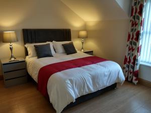 una camera da letto con un grande letto con una coperta rossa e bianca di Woodview Bed & Breakfast a Kilkeel