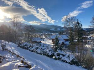 a village covered in snow with mountains in the background at Chata Sovička in Zuberec
