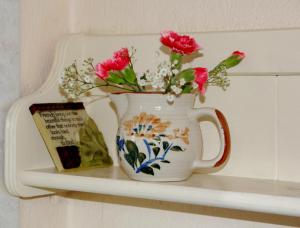a vase with flowers in it sitting on a shelf at Corriebrack cottage in Hollywood