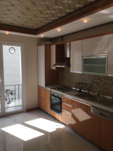 a kitchen with a sink and a stove and a window at Residence Gurpinar Grand Luxe Beach + Wifi + parking privé in Istanbul